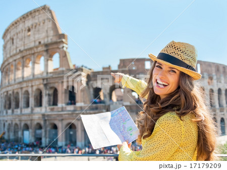 Happy young woman with map pointing on colosseum in rome, italy 17179209