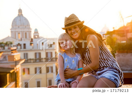 Portrait of happy mother and baby girl sitting on street overloo Portrait of happy mother and baby girl sitting on street overloo 17179213