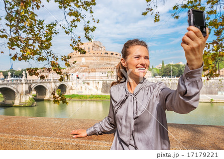 Smiling young woman making selfie on embankment near castel sant Smiling young woman making selfie on embankment near castel sant 17179221