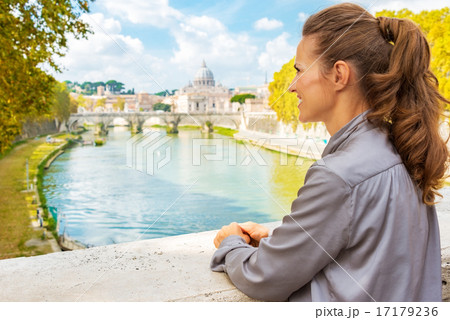 Young woman looking into distance while on bridge with view on b Young woman looking into distance while on bridge with view on b 17179236