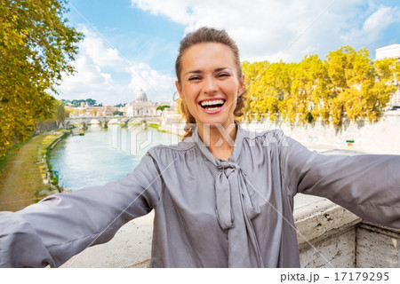 Smiling young woman making selfie on bridge ponte umberto I with 17179295