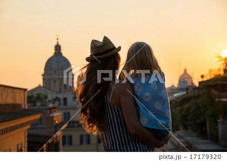 Silhouette of mother and baby girl looking on rooftops of rome o 17179320