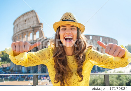 Young woman showing thumbs up in front of colosseum in rome, ita Young woman showing thumbs up in front of colosseum in rome, ita 17179324