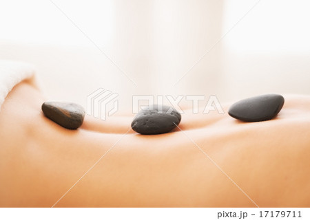 Closeup on young woman receiving hot stone massage Closeup on young woman receiving hot stone massage 17179711