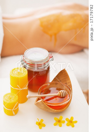 Closeup on honey spa therapy ingredients and young woman in back Closeup on honey spa therapy ingredients and young woman in back 17179782