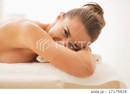 Happy young woman laying on massage table 17179828