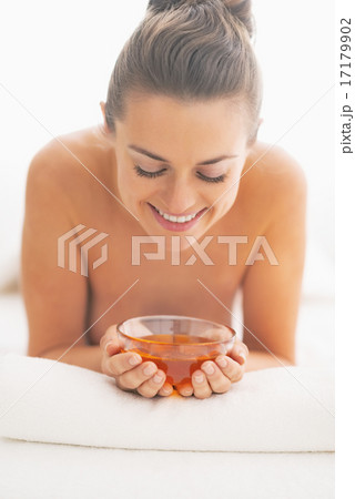 Young woman on massage table holding plate with honey Young woman on massage table holding plate with honey 17179902