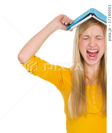 Angry student girl with book over head 17180001