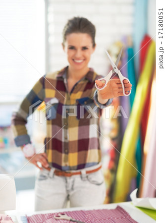 Closeup on happy tailor woman showing scissors 17180051