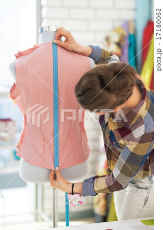 Tailor woman working with dress in studio. rear view Tailor woman working with dress in studio. rear view 17180062