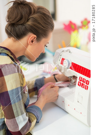 Seamstress working with sewing machine. rear view 17180285