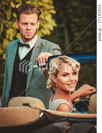 Wealthy couple in a classic convertible 17182813