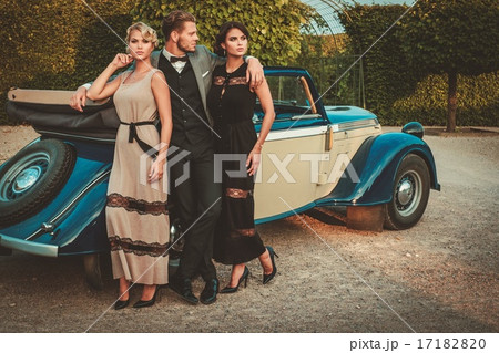 Wealthy friends near classic convertible 17182820
