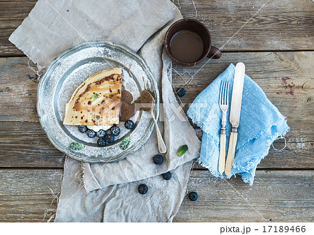 Thin pancake or crepe with fresh blueberry, cream, mint, and salty caramel sauce in vintage metal Thin pancake or crepe with fresh blueberry, cream, mint, and salty caramel sauce in vintage metal 17189466