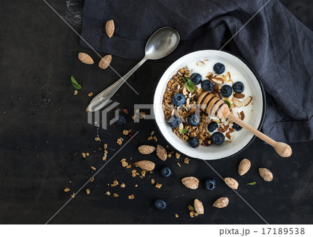 Healthy breakfast. Oat granola with fresh blueberries, almond, yogurt and mint in a rustic metal 17189538