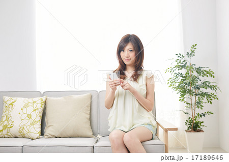 ソファ 女子大生 スマホの写真素材