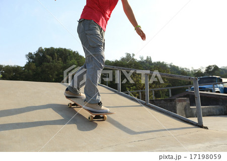 skateboarder legs riding skateboard at skatepark  17198059