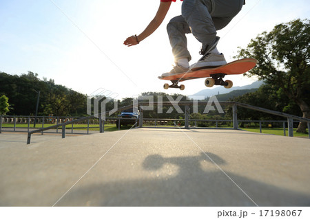 skateboarder legs doing a ollie at skatepark 17198067