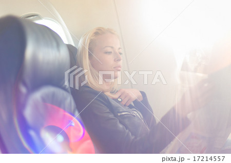 Woman reading newspaper on airplane. 17214557