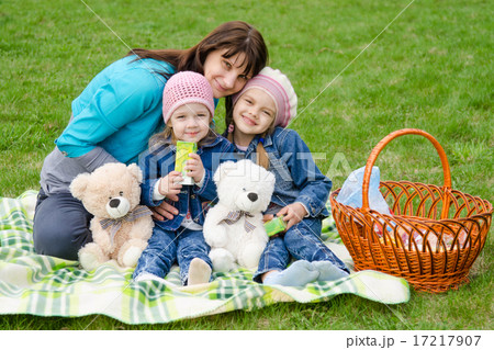 Mum embraces daughters on a picnic Mum embraces daughters on a picnic 17217907