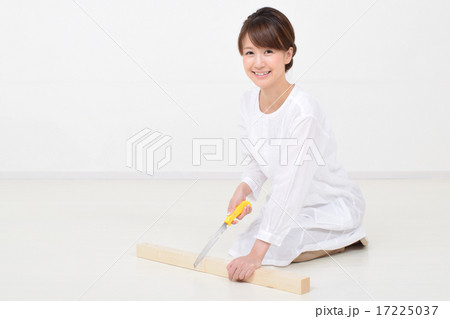 ノコギリで角材を切る女性 17225037
