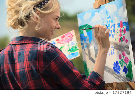 Beautiful blonde woman artist paints a colorful picture. 17227194