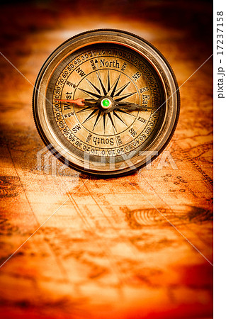 Vintage compass lies on an ancient world map. 17237158