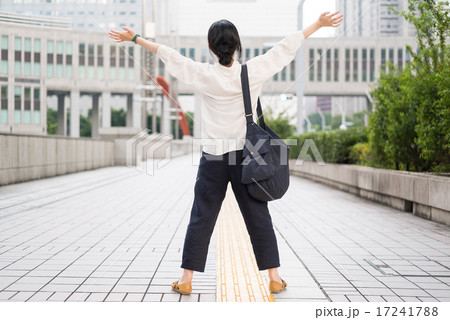 歩道で大きく腕を広げる女性 17241788