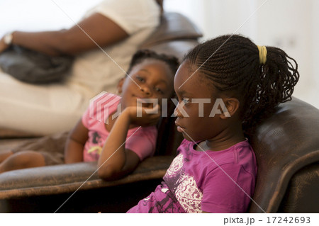 Two little black sisters sitting on armchairs 17242693