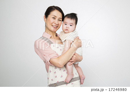 赤ちゃんを抱っこするシニア女性の写真素材