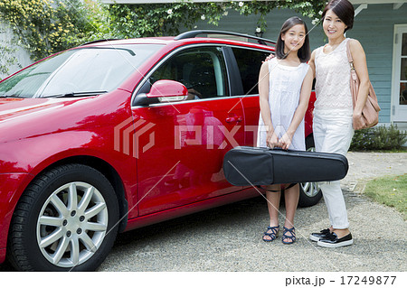 車の横に立つ10代の女の子とお母さんの写真素材