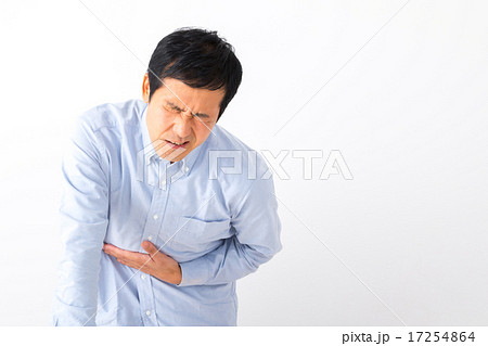 男性 腹痛 病気 男性 ミドル世代 中高年 短髪の男性 二日酔い 普段着 男の人 体調不良 胃もたれの写真素材