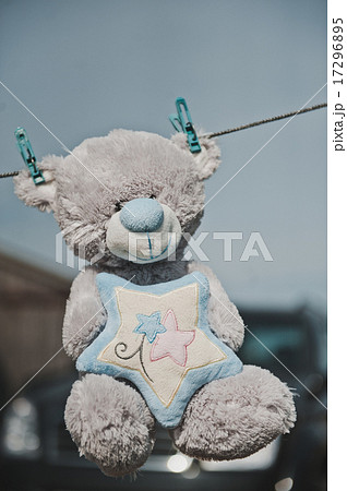 The toy bear hangs on clothespins 2359. 17296895