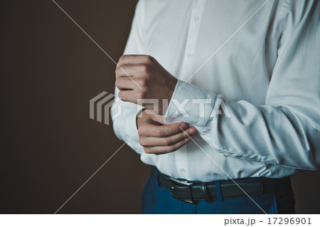 The young man dresses cuff links on a shirt 2291. 17296901