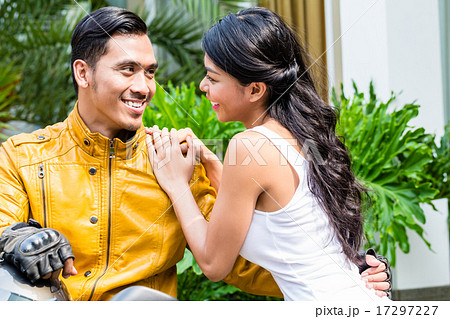 Woman saying goodbye to motorcyclist 17297227