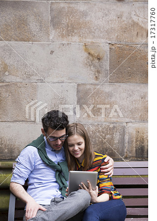 Caucasian couple using a digital tablet outdoors. Caucasian couple using a digital tablet outdoors. 17317760
