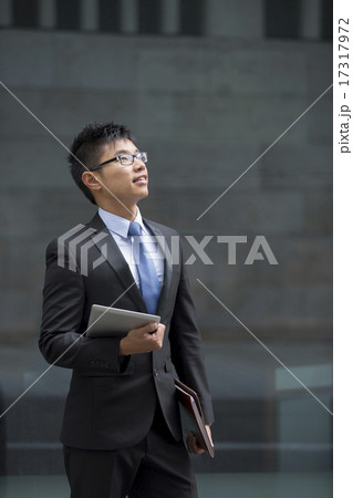 Asian businessman outside modern office building. 17317972