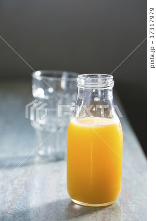 Bottle of Orange juice on a rustic wooden table. 17317979