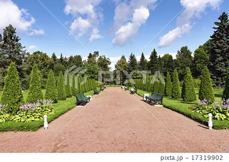 park walkway with benches for rest and flower beds 17319902