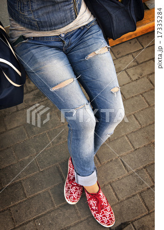girl in ripped jeans sitting on the bench girl in ripped jeans sitting on the bench 17335284