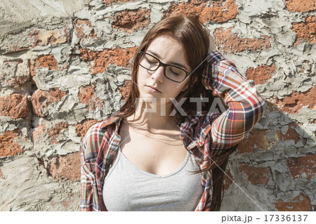 Stunning young woman posing outdoor over brick wall. 17336137