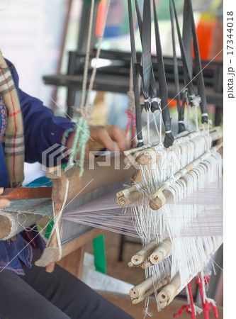 Woman weaving white pattern on loom 17344018