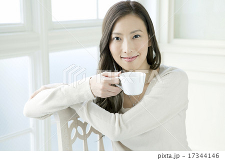 部屋でリラックスする２０代女性 17344146