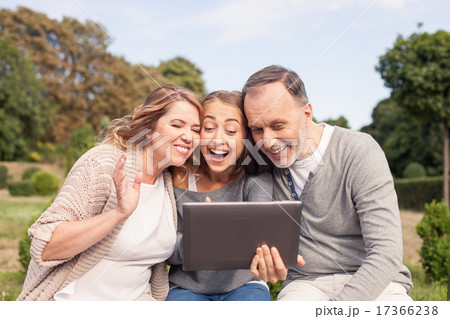 Beautiful girl is showing tablet to her old parents 17366238