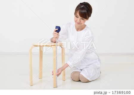 メジャーで椅子を測る女性 メジャーで椅子を測る女性 17369100