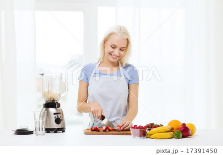 smiling woman with blender preparing shake at home smiling woman with blender preparing shake at home 17391450