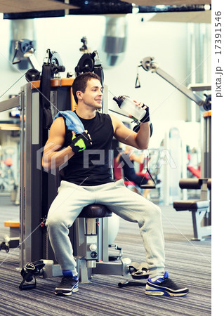 smiling man exercising on gym machine smiling man exercising on gym machine 17391546