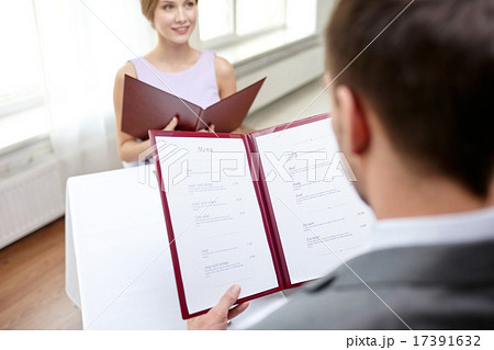 close up of couple with menu at restaurant close up of couple with menu at restaurant 17391632