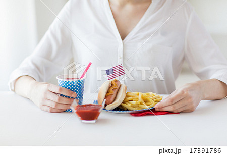 close up of woman eating hotdog and french fries close up of woman eating hotdog and french fries 17391786