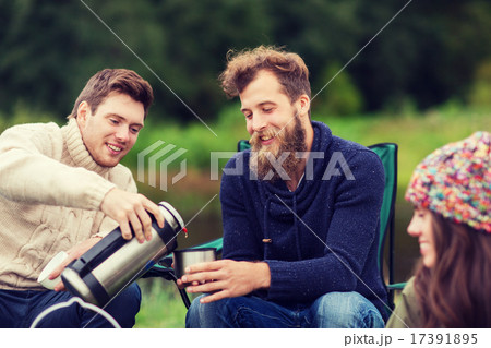 group of smiling tourists cooking food in camping group of smiling tourists cooking food in camping 17391895